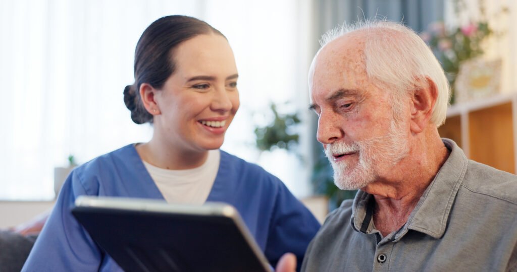 Betreuungskraft bei einem Beratungseinsatz in Gelsenkirchen mit einem Senior an einem Tablet